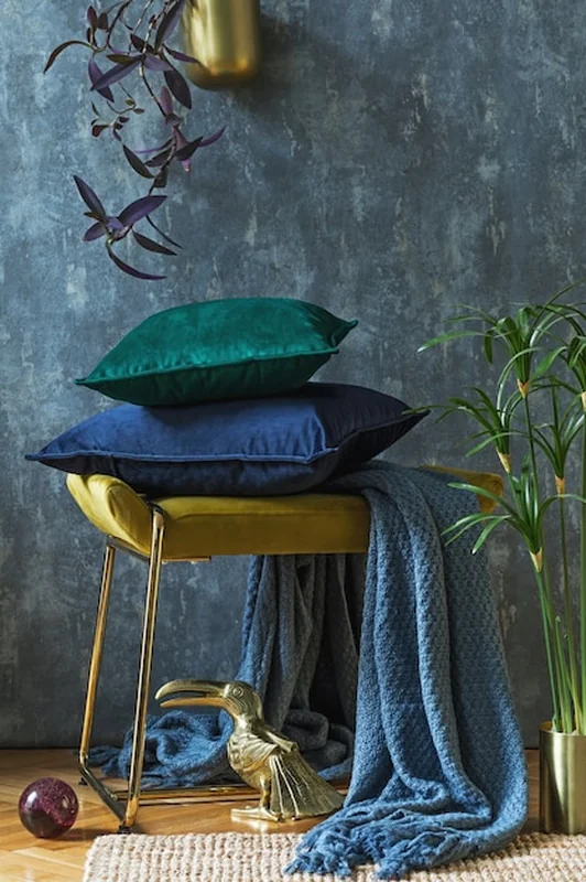 Kompozycja detali wnętrza salonu z poduszkami i szarymi ścianami