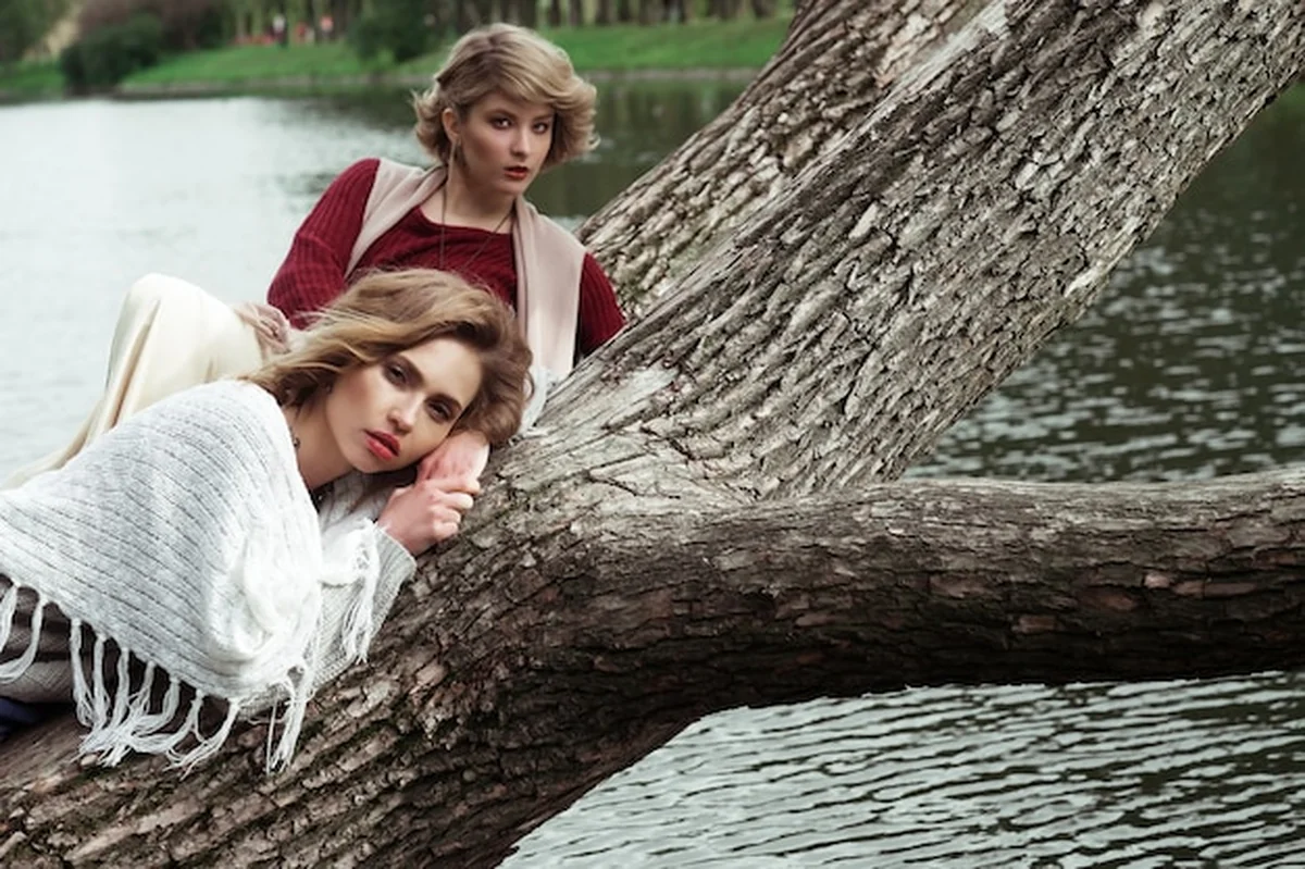 Dwie piękne kobiety na drzewie obok jeziora