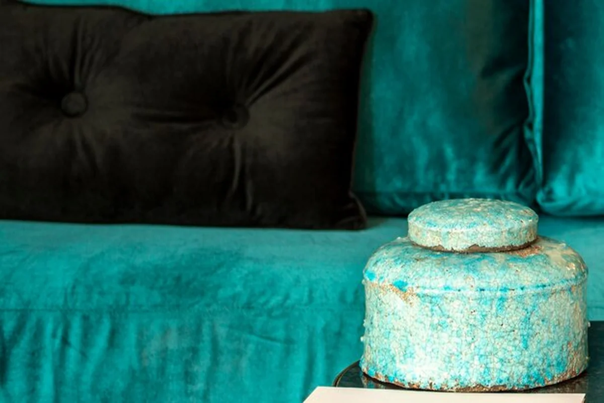 Detal salonu z niebieską misą i aksamitną sofą