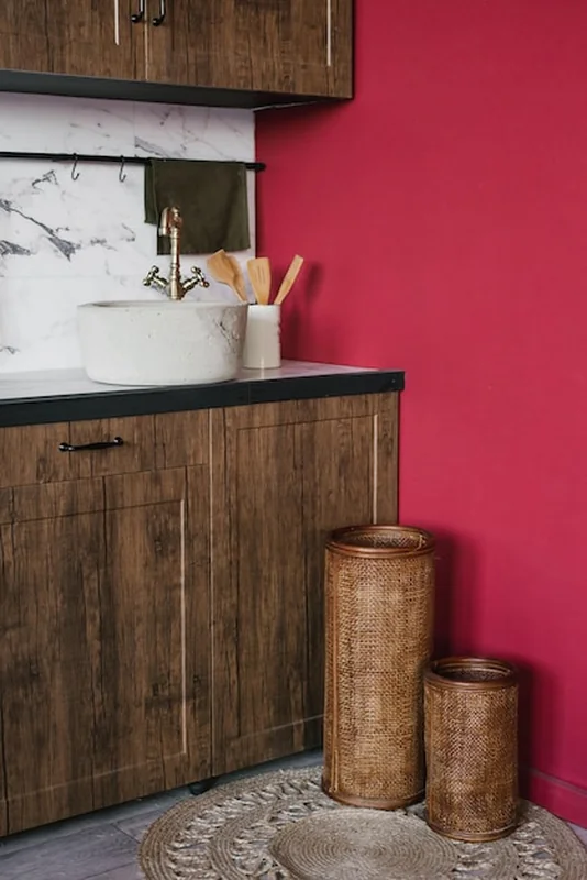 Rustyczne wnętrze kuchni z vintage zlewem i burgundzkimi ścianami