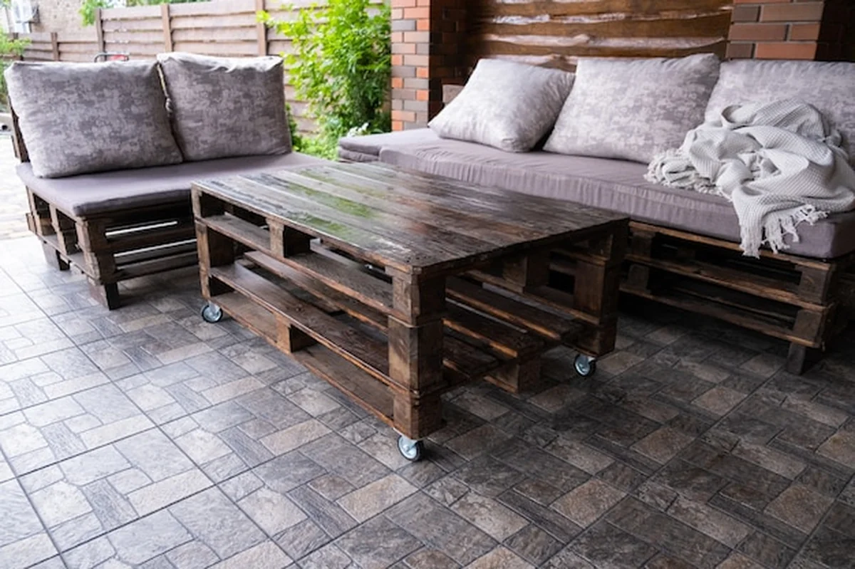 Meble z palet w altanie: sofa i stół w części wypoczynkowej z grillem