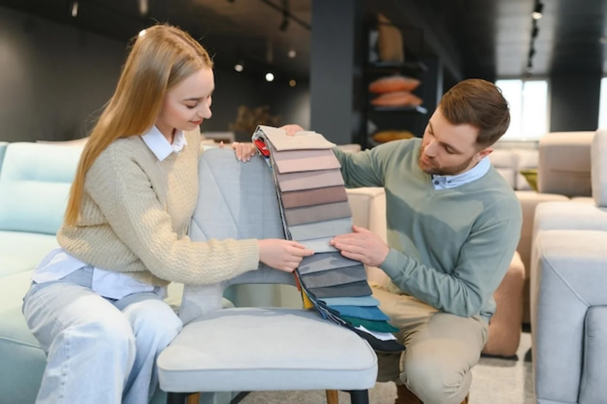 Kobieta i mężczyzna patrzą na próbkę włókienniczą w sklepie z meblami