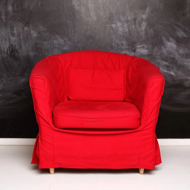 Czerwony koncepcyjny fotel obok pustej tablicy