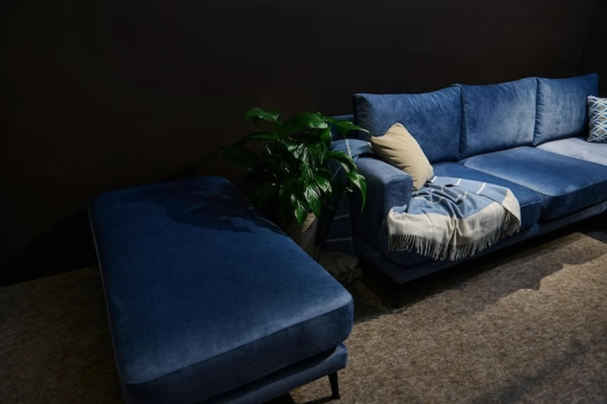 Nowoczesna granatowa sofa z beżowymi poduszkami w hali wystawienniczej