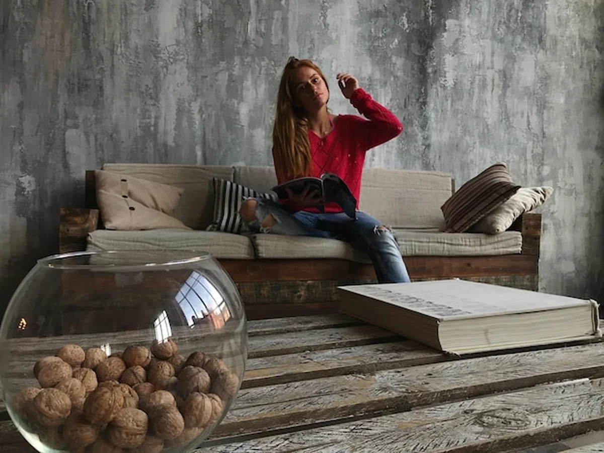 Kobieta siedząca na rudym kanapie w domu