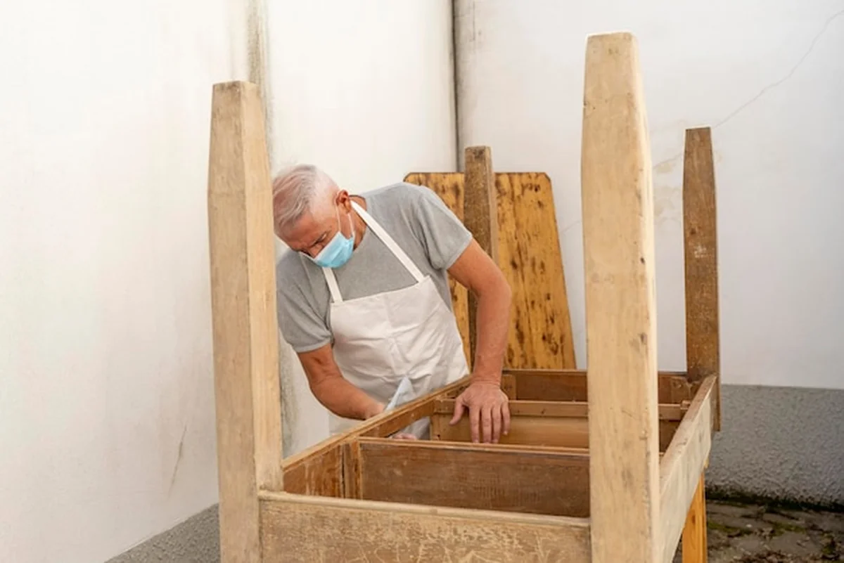 Zawodowy stolarz buduje drewniany stół w warsztacie na świeżym powietrzu