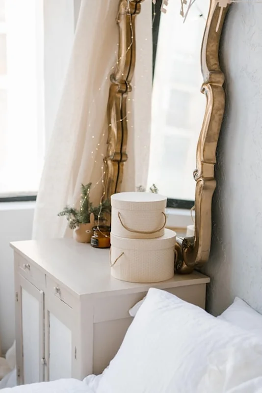 Lustro nad komodą we wnętrzu sypialni ozdobionej na Boże Narodzenie