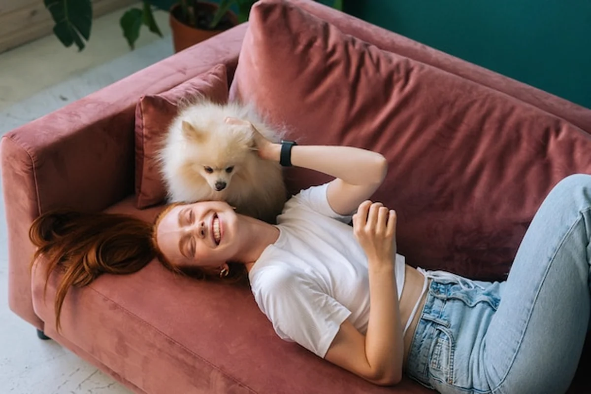 Młoda kobieta z psem na białej sofie