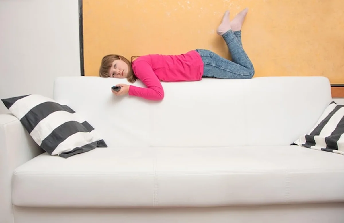 Kobieta leżąca na kanapie w domu