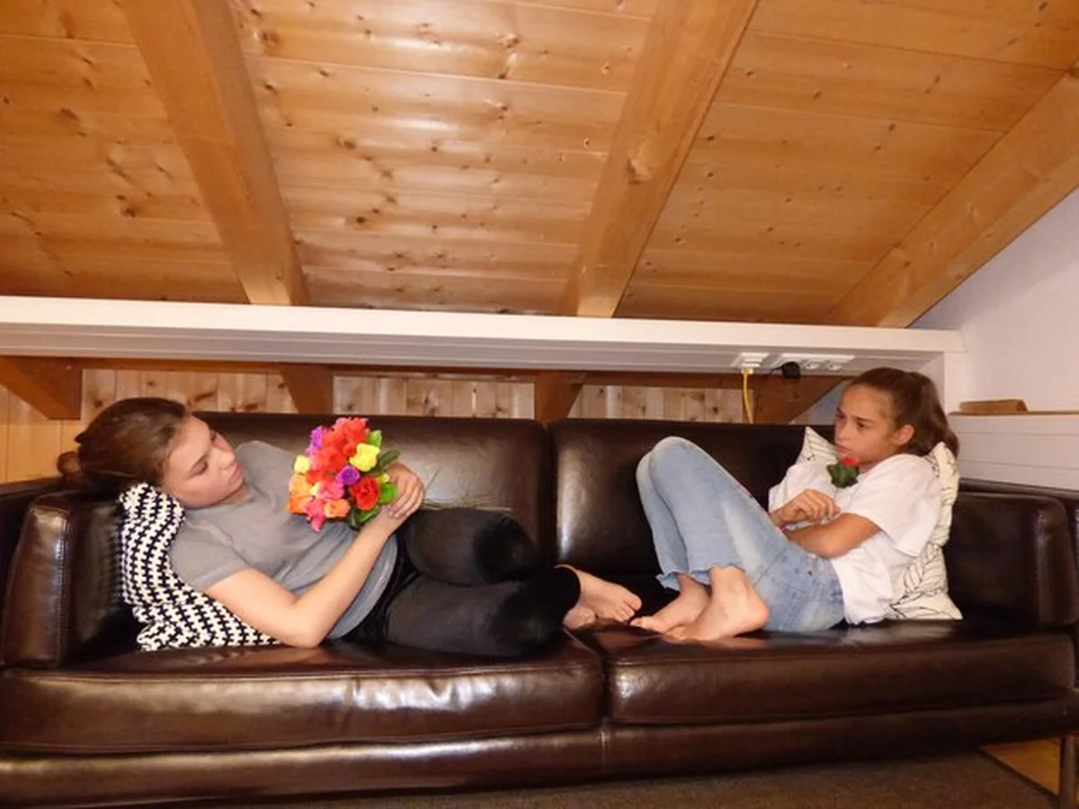 Siostry z kwiatami na kanapie w domu