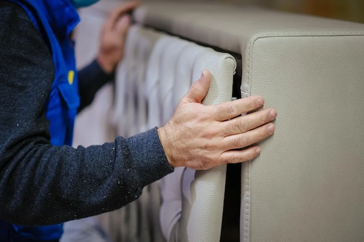 Pracownik montuje białą kanapę