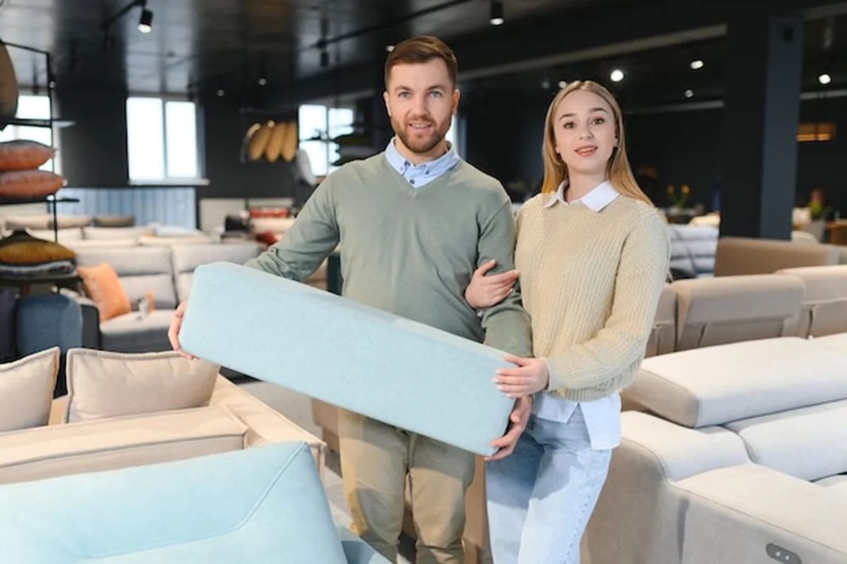 Para wybierająca kanapę i poduszki w sklepie z meblami