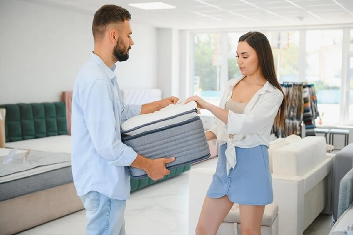 Piękna młoda para wybiera materac w sklepie