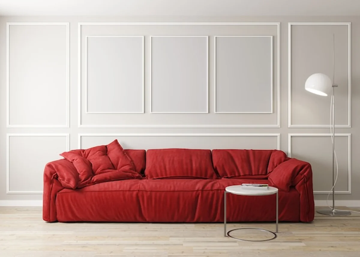 Jasny salon z czerwoną sofą, lampą i stolikiem kawowym