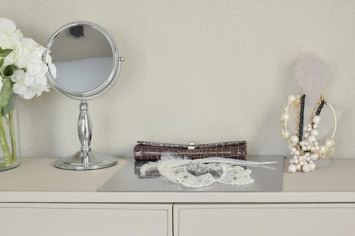 Lustro, biżuteria i zestaw do makijażu na stole