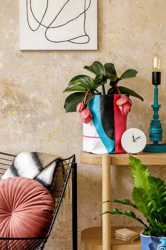 Neutralna kompozycja salonu z brązową ramką, drewnianą konsolą, roślinami i dekoracjami