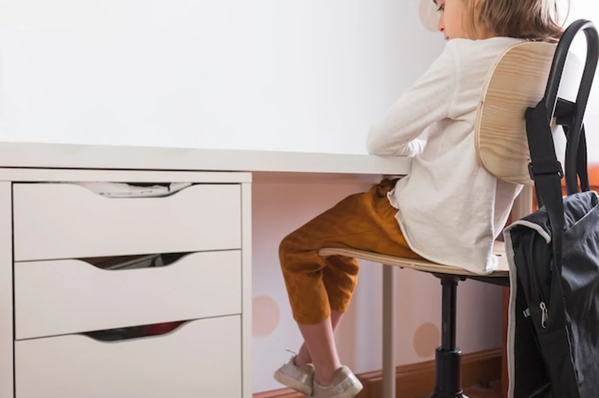 Dziewczyna siedzi przy biurku w domu