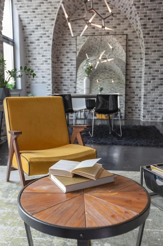 Wnętrze mieszkania w stylu loft z jasnymi akcentami i miękkim fotelem