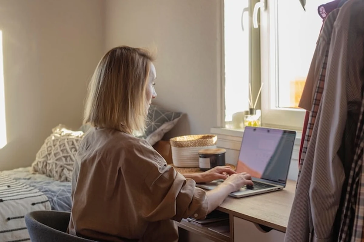 Kobieta pracuje zdalnie w przytulnej sypialni