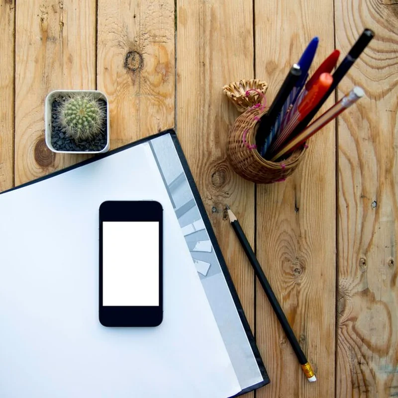 Telefon komórkowy z książką na drewnianym stole