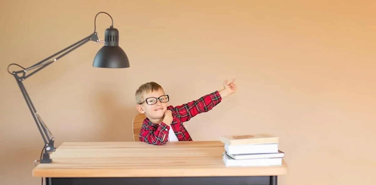 Chłopiec i książki na stole przy ścianie