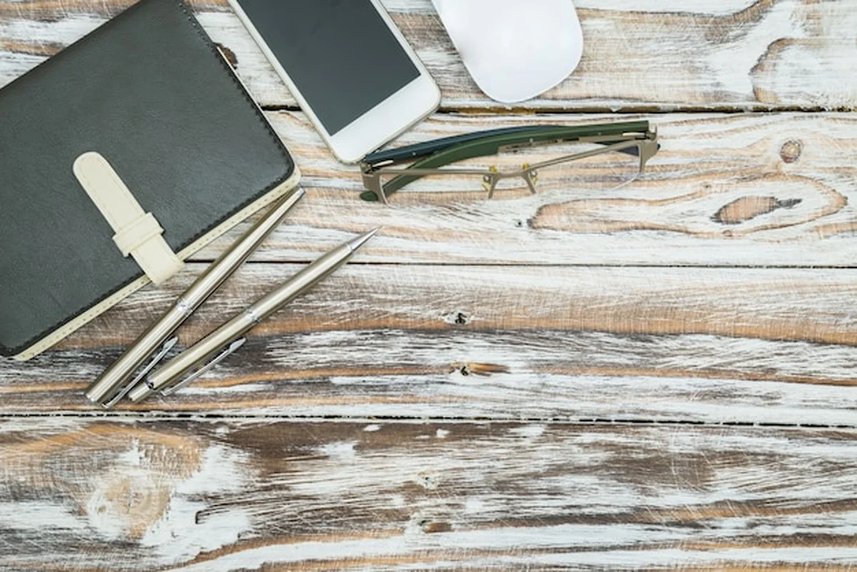 Drewniany stół z materiałami biurowymi widziany z góry