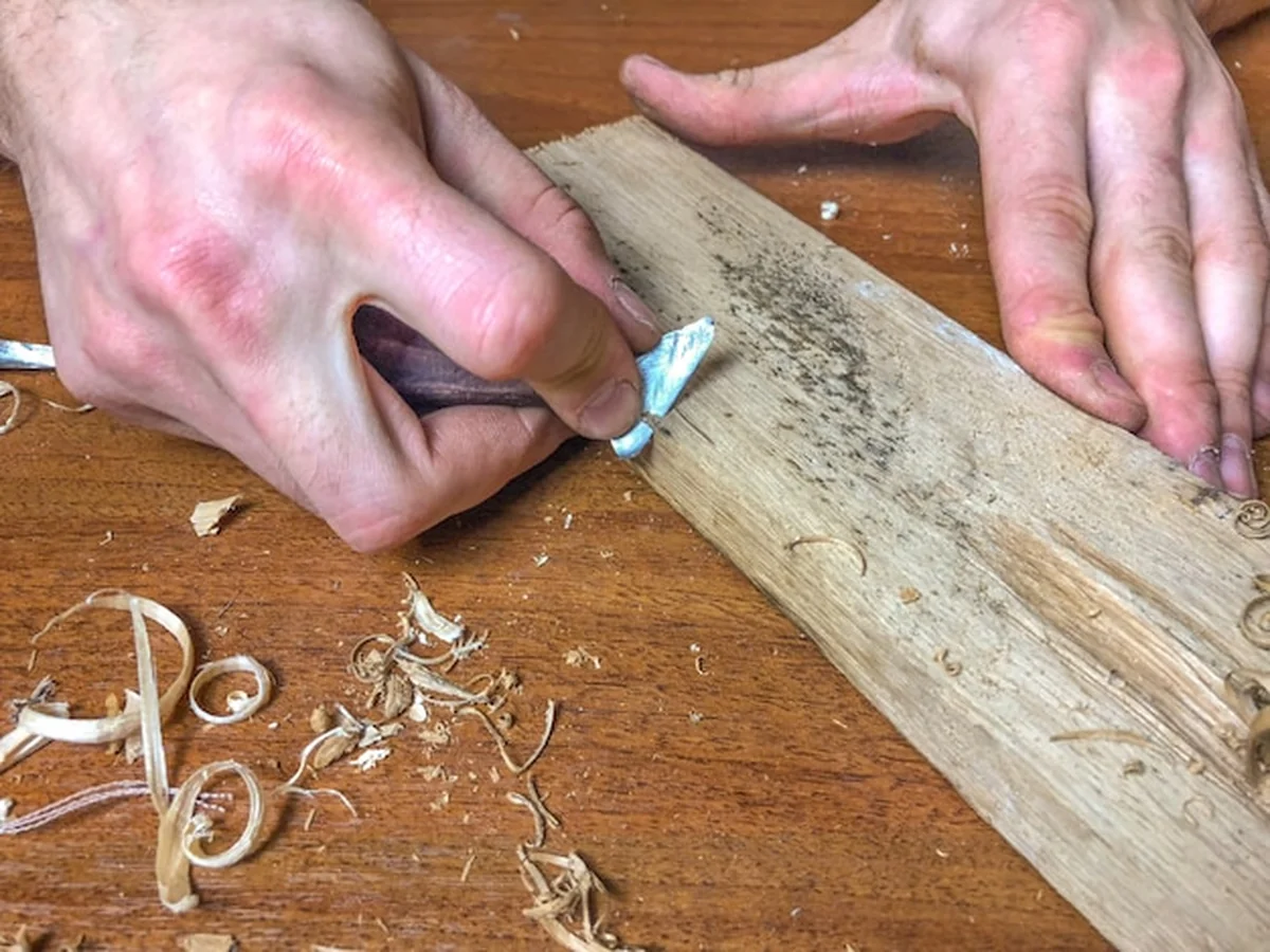 Cieśla obrabia drewno ręcznie