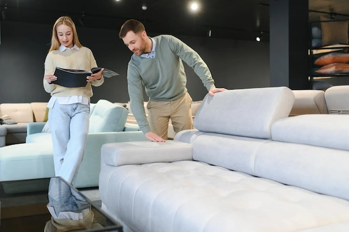 Para wybierająca kanapę i poduszki w sklepie z meblami